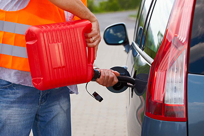 AER Towing Jumpstart Service Man putting gas in a car from a red can